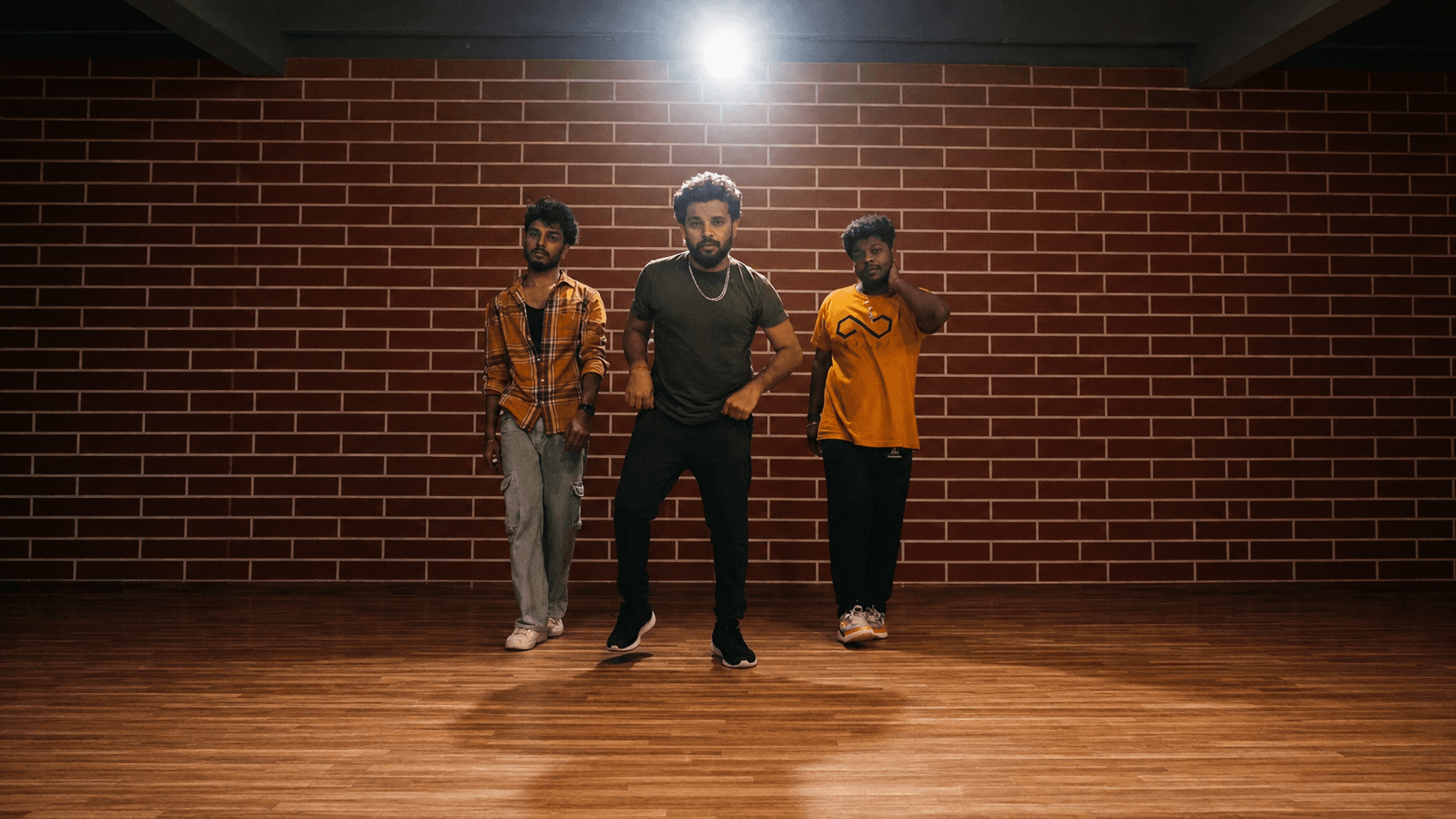 Three dancers mid-routine under the studio lights