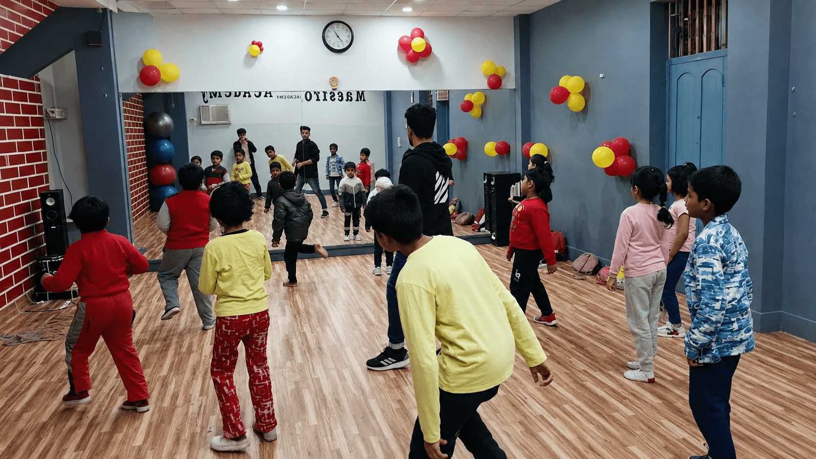 A festive group class with balloons across the hall