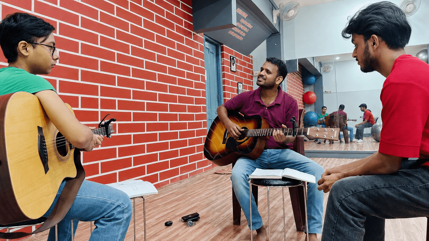 Guitar lesson in progress against the brick wall